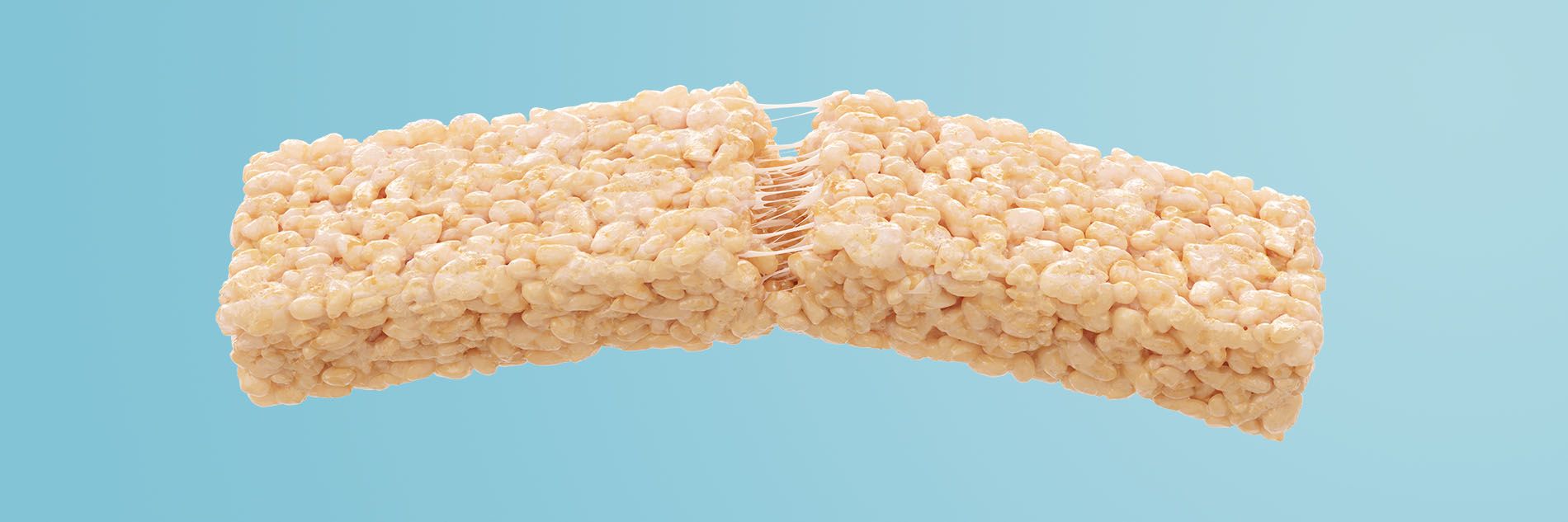 Extra Long Rice Krispies Treats® Floating in a light blue background showing strings of marshmallow in the middle of the treat